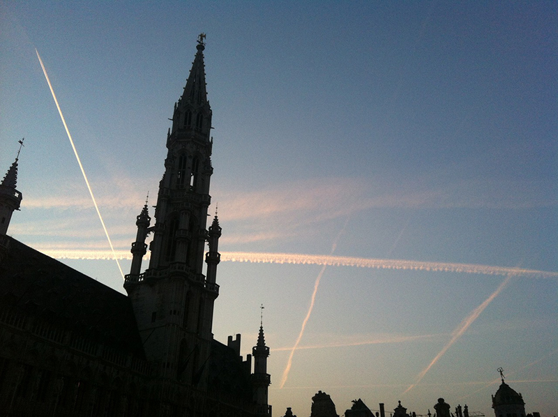 Rastos de condensação de aviões no céu de Bruxelas – que os teóricos da conspiração dos “chemtrails” alegam ser substâncias que os governos pulverizam para manterem as populações subjugadas. Foto por António Gomes da Costa.